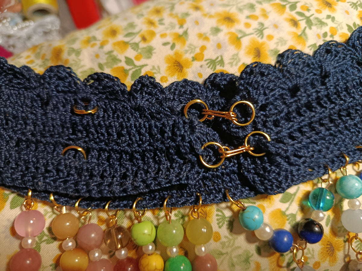 Détail de la fermeture ajustable du collier EBRULI sur sa bande crochetée sombre